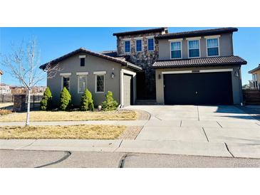 Charming two-story home with a stone facade, spacious driveway, and well-maintained front yard at 15454 W Auburn Ave, Lakewood, CO 80228