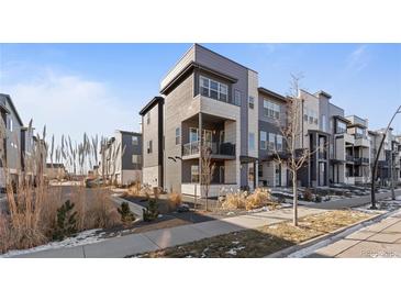 Modern three-story townhome with light gray and white exterior at 1415 W 68Th Ave, Denver, CO 80221