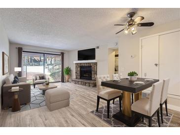 Inviting living room boasts a stone fireplace and sliding glass doors to outdoor view at 4281 S Salida Way # 8, Aurora, CO 80013