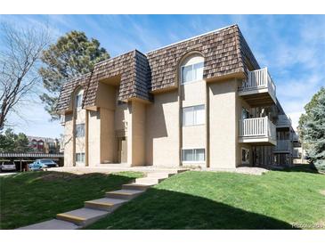 This exterior shows a two-story apartment building with a well-manicured lawn and a beautiful roof at 7455 E Quincy Ave # 204, Denver, CO 80237