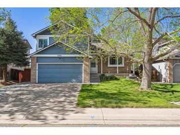 Charming two-story home with a well-manicured lawn, attached two-car garage, and appealing brick and siding facade at 11431 W Lake Dr, Littleton, CO 80127