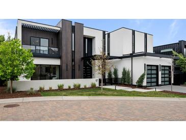 Modern home with a black and white exterior, accented with wood paneling and manicured landscaping at 2821 E Cedar Ave # 17, Denver, CO 80209