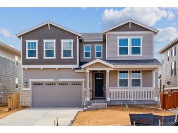 Charming two-story home boasts a covered porch, two-car garage, and attractive mixed-material facade at 25254 E Warren Pl, Aurora, CO 80018