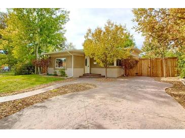 Charming single-story home with a spacious front yard, mature trees, and wide driveway at 3835 Pecos St, Denver, CO 80211