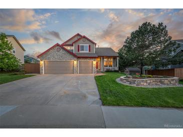 Charming two-story home featuring a stone facade, three-car garage, and landscaped front yard at 5048 Rocky Mountain Dr, Castle Rock, CO 80109