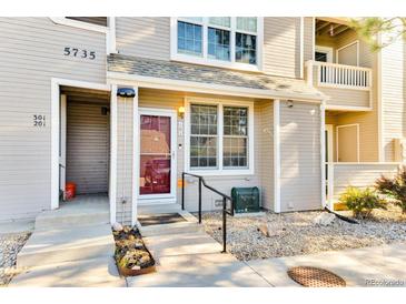 Inviting front entrance with well-maintained landscaping and a charming red door at 5735 W Atlantic Pl # 101, Lakewood, CO 80227