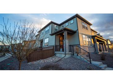Inviting two-story home featuring professional rock landscaping, a cozy front porch, and neutral siding at 359 Courtfield Way, Castle Pines, CO 80108