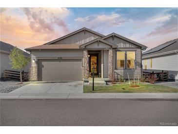 Charming single-Gathering home with a two-car garage and professionally landscaped front yard at dusk at 21436 E Stanford Ave, Aurora, CO 80015