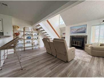 Inviting living room with plush seating, fireplace, and staircase to the upper level at 13781 E Lehigh Ave # E, Aurora, CO 80014