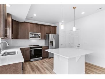 Modern kitchen with stainless steel appliances, island, and lots of storage space at 1182 Sugarloaf Ln, Erie, CO 80516