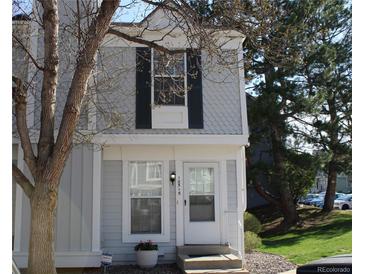 Charming townhome with white trim, black shutters, and well-maintained front lawn at 10515 W Dartmouth Ave, Lakewood, CO 80227