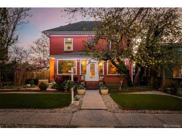 Charming red brick home featuring an inviting walkway and manicured front yard at sunset at 1521 Pontiac St, Denver, CO 80220