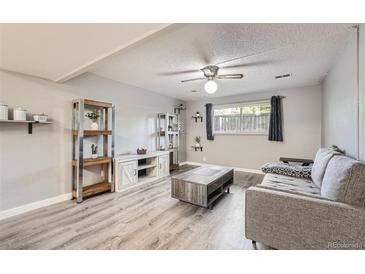 Inviting living room with a ceiling fan, light gray walls, wood-style flooring, and a comfortable couch at 1612 Cottonwood Dr # 2W, Louisville, CO 80027