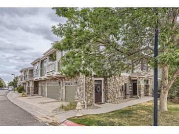 Exterior of townhome with stone and siding, attached garage, and landscaping at 12832 Mayfair Way # F, Englewood, CO 80112