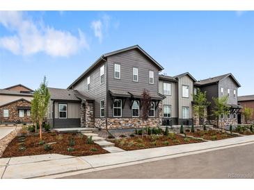 Charming gray two-story home with stone accents and landscaped front yard at 9756 Mount Kataka Pt, Littleton, CO 80125