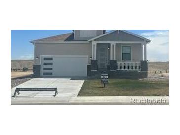 Charming single-Gathering home with a modern garage door and covered front porch at 42976 Colonial Trl, Elizabeth, CO 80107