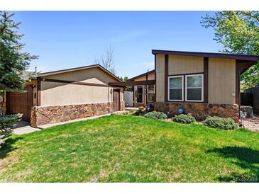 Charming single-story house featuring a well-manicured lawn and partial stone facade, creating inviting curb appeal at 214 Poppy St, Golden, CO 80401