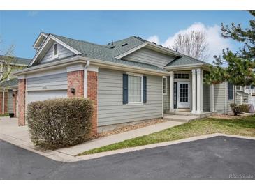Charming home featuring a gray siding exterior, well-manicured lawn, and inviting entrance at 12879 E Dickensen Pl, Aurora, CO 80014