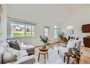 Bright living room with vaulted ceiling, natural light, neutral decor and hardwood floors at 494 Owl Dr # 4, Louisville, CO 80027