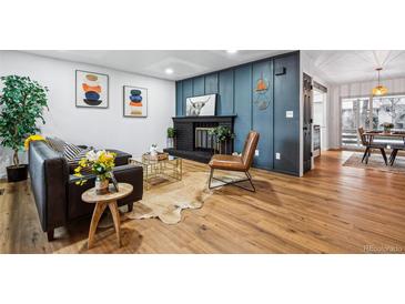 Inviting living room with a stylish fireplace and a leather sofa, perfect for relaxing and entertaining at 6885 E Briarwood Cir, Centennial, CO 80112