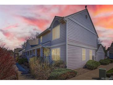 Charming multi-level home featuring tidy landscaping, a columned front porch, and muted siding at 7912 S Depew St # A, Littleton, CO 80128