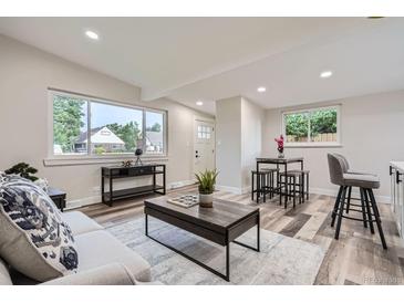 Bright living room with updated flooring, neutral walls, and a dining area by the window at 3654 Fairfax St, Denver, CO 80207