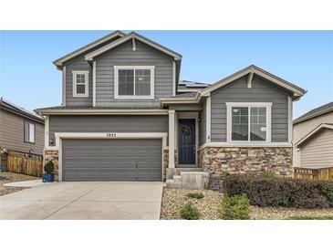 Charming two-story home showcasing a gray facade, stone accents, and a well-manicured front yard at 7833 Bandit Dr, Castle Rock, CO 80108