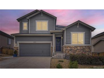 Charming two-story home with gray siding, stone accents, covered entry, and attached two-car garage at 7833 Bandit Dr, Castle Rock, CO 80108