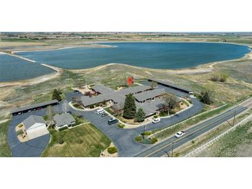 An aerial view of a brick building near a picturesque lake on a sunny day at 5425 County Road 32 # 14, Mead, CO 80504