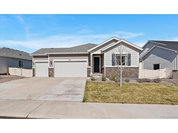 Beautiful single-Gathering home featuring a well-manicured lawn, three-car garage and stone facade at 5611 Saddle Skirt St, Parker, CO 80134