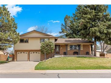 Charming two-story home with a well-manicured lawn, brick accents, and a two-car garage, perfect for Gathering living at 2160 S Flower St, Lakewood, CO 80227