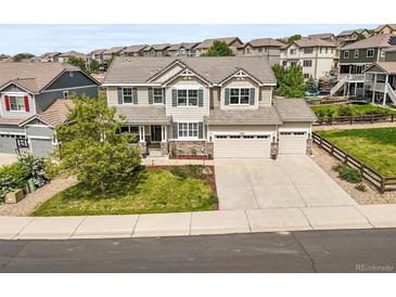 Inviting two-story home featuring a three-car garage, well-manicured lawn, and beautiful landscaping at 2090 Bellavista St, Castle Rock, CO 80109