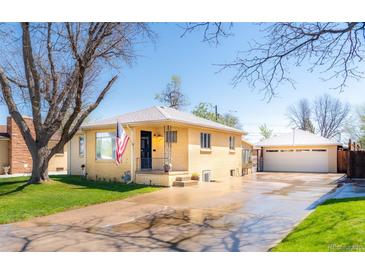 Charming yellow brick home with a well-manicured lawn, an American flag, and a detached two-car garage at 2548 S Zurich Ct, Denver, CO 80219