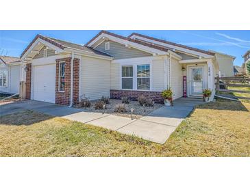Charming single-story home featuring a brick facade, well-maintained lawn, and inviting front entrance at 200 Vista Blvd, Brighton, CO 80603