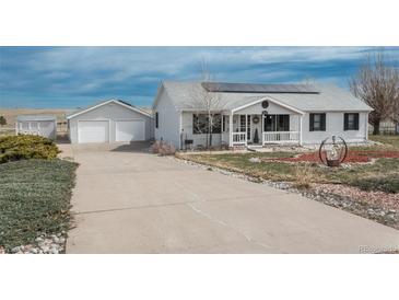 Charming home featuring a detached garage and solar panels with a well-manicured lawn and long driveway at 34280 Columbine E Trl, Elizabeth, CO 80107