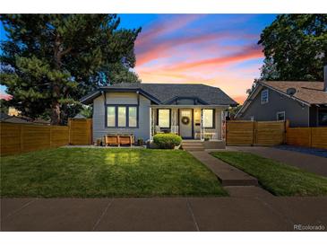 Charming single-story home with a well-manicured lawn and cozy front porch, framed by mature trees and a sunset sky at 4312 Xavier St, Denver, CO 80212