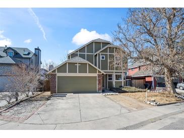 Charming two-story home featuring a well-maintained lawn, mature tree, and attached two-car garage at 4311 Del Rio Ct, Denver, CO 80239