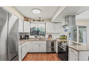Well-lit kitchen boasts stainless steel appliances and granite countertops at 5512 S Greenwood St, Littleton, CO 80120