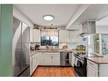 Charming kitchen featuring granite counters, stainless steel appliances, and wood flooring at 5512 S Greenwood St, Littleton, CO 80120