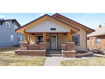 Charming bungalow featuring a welcoming front porch with brick accents and a well-maintained lawn at 3225 S Sherman St, Englewood, CO 80113