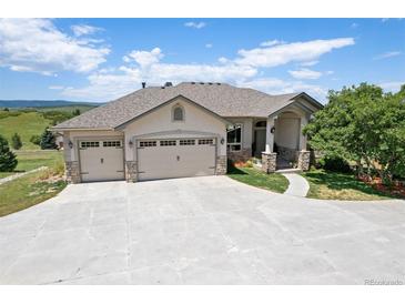 Beautiful home featuring an attached three-car garage and a meticulously maintained lawn at 4002 Bell Mountain Dr, Castle Rock, CO 80104