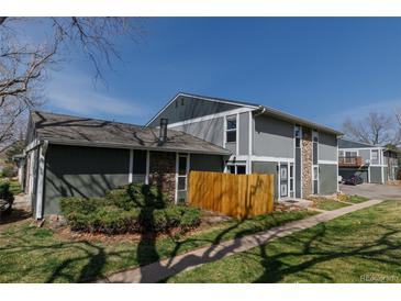 Townhome featuring stone accents and green landscaping at 10001 E Evans Ave # 72C, Aurora, CO 80247