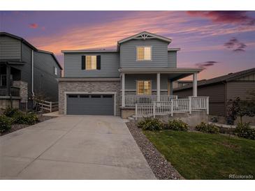 Charming two-story home with stone accents, a covered porch, and well-maintained landscaping at 5201 Lumos Ln, Castle Rock, CO 80104