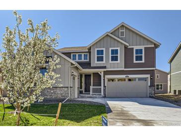 Charming two-story home featuring a stone accents, attached two-car garage and landscaped yard at 4600 Thistle Dr, Brighton, CO 80601