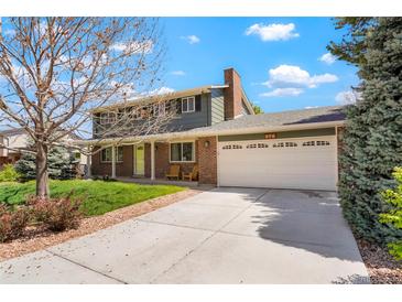 Two-story home featuring a brick and gray siding exterior, a two-car garage, and a well-manicured front yard at 978 Mercury Cir, Lone Tree, CO 80124