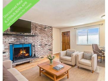 Comfortable living room features a brick fireplace with a mounted television and bright window at 155 S Pennsylvania St # 311, Denver, CO 80209