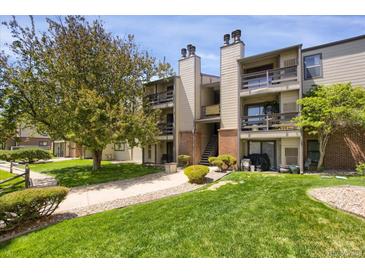 A well-maintained condo building with lovely green space and mature trees surrounding the property at 519 Wright St # 108, Lakewood, CO 80228
