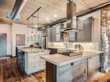 Modern kitchen with stainless steel appliances, pendant lights and exposed ductwork in a loft style apartment at 1401 Wewatta St # 308, Denver, CO 80202