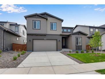 Two-story home with neutral siding, attached garage, xeriscaping, and neatly trimmed lawn at 9972 Wheeling St, Commerce City, CO 80022