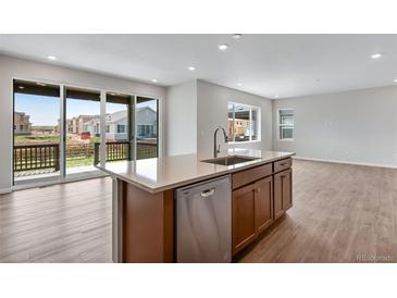 Bright, modern kitchen with island, stainless steel appliances, and sliding glass doors at 9972 Wheeling St, Commerce City, CO 80022